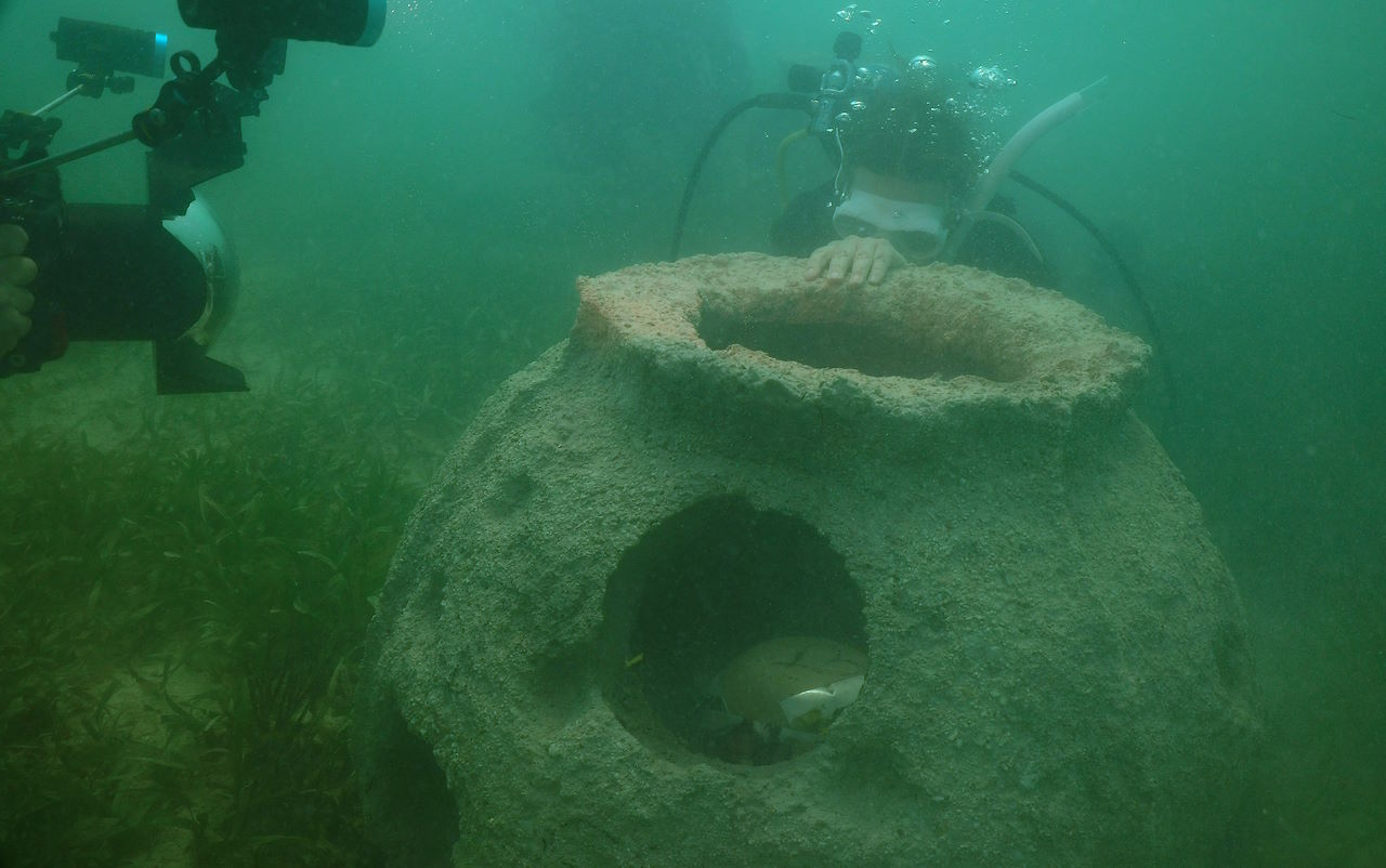 SCUBA divers in water adjusting reef ball