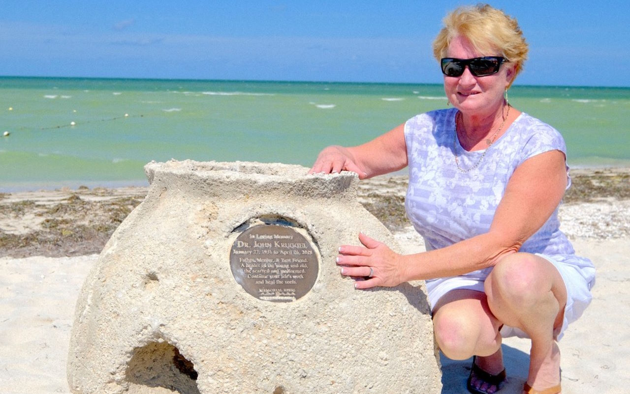 family beside reef ball with bronze placard in Silcer